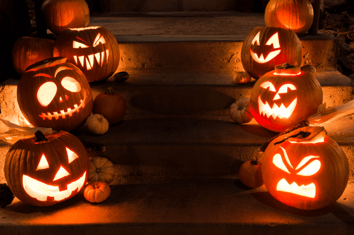 Escalier de maison bordée de citrouilles sculptées illuminées le soir de l'Halloween.