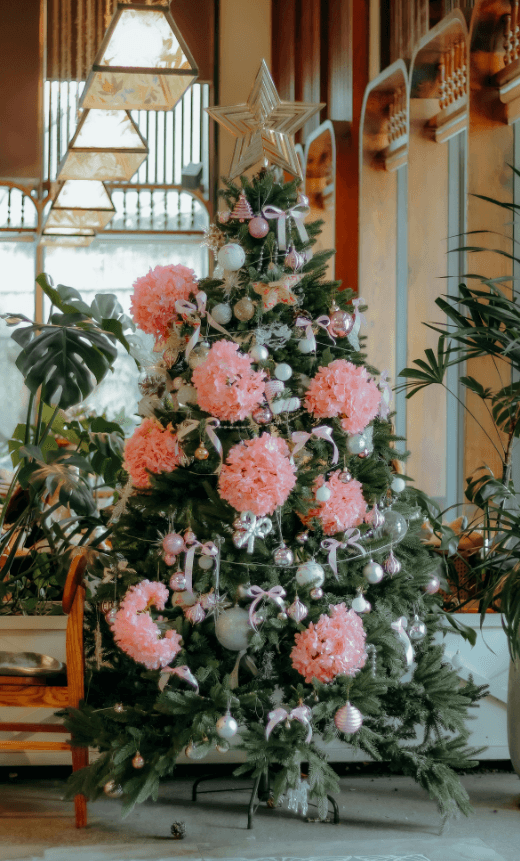 Sapin de Noël décoré de grosses fleurs roses
