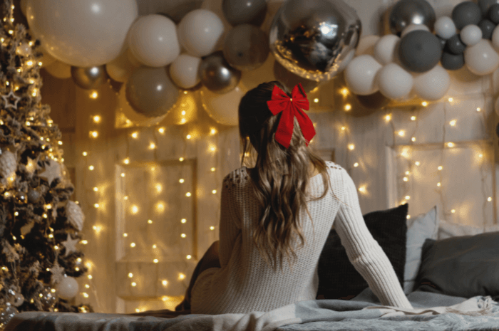 Femme vu de dos devant un décor de Noël agrémenté de ballons