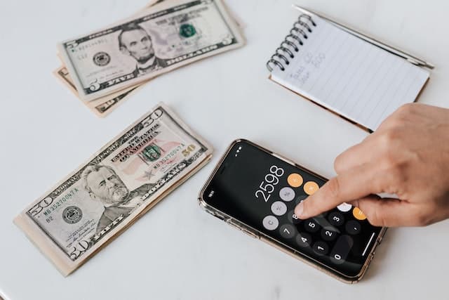 Personne calculant le montant de son retour de taxe sur une calculatrice