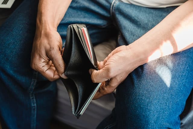 Homme tenant un portefeuille vide