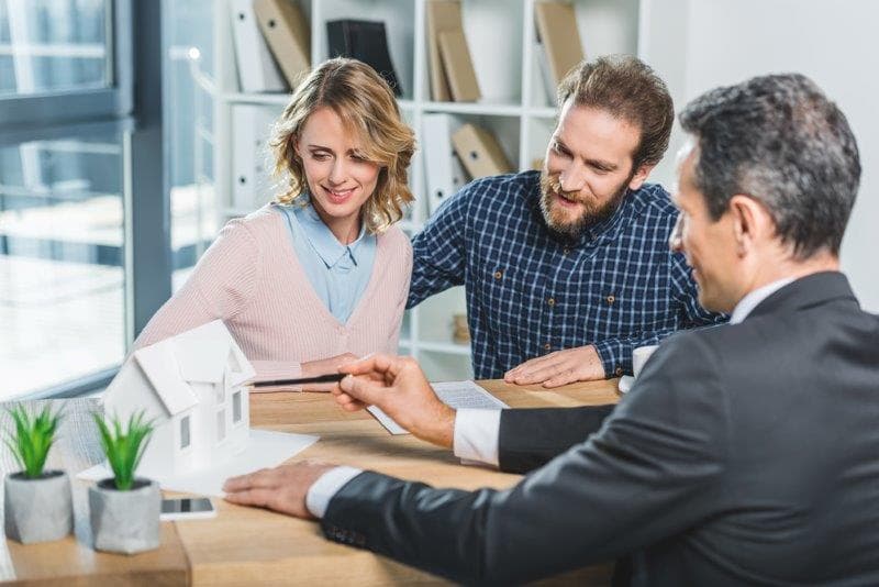Couple d'emprunteurs refinançant leur hypothèque avec leur courtier