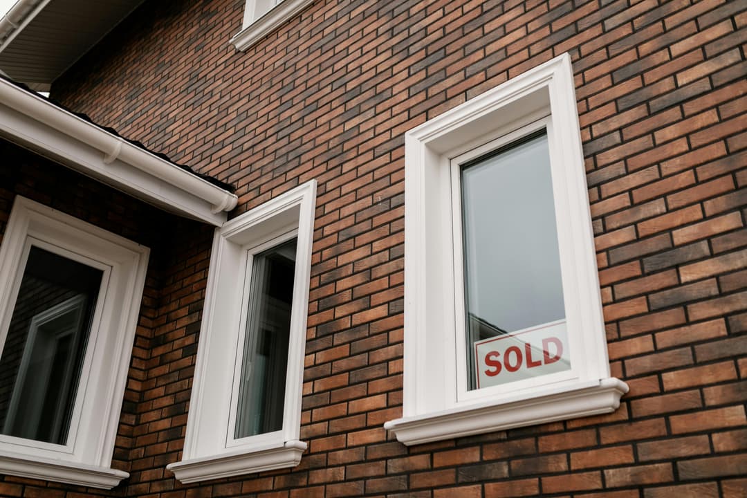 Immeuble avec une pancarte "vendue" dans la fenêtre