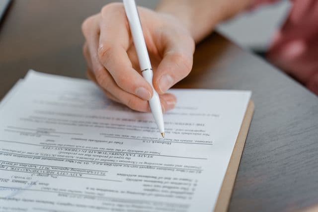 Femme remplissant un formulaire de Déclaration du vendeur