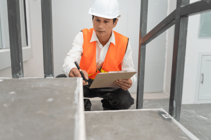 Inspecteur en bâtiment examinant les marches d'un escalier en rénovation