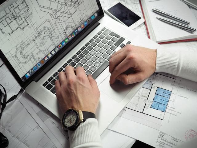 Architecte regardant un plan de maison à l'ordinateur