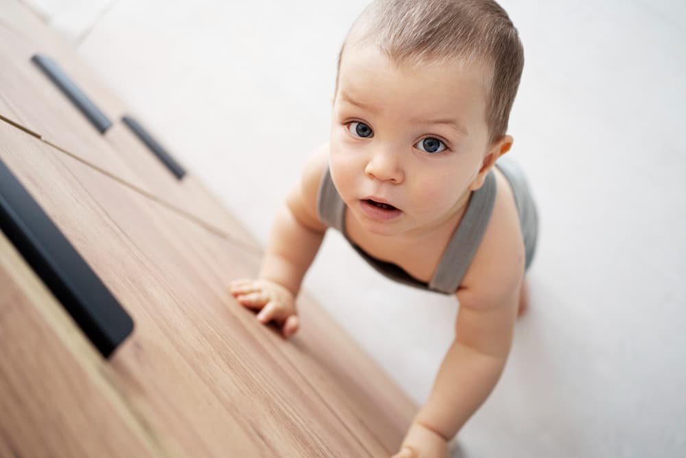 Bébé voulant grimper un meuble