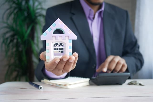 Courtier hypothécaire tenant une petite maison