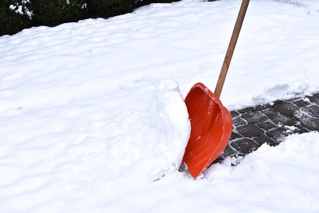 Un locataire déneige devant sa propriété