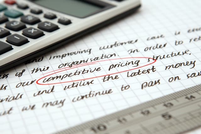 Prix compétitif entouré sur une feuille avec calculatrice
