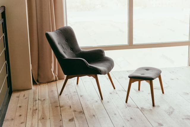 Fauteuil et pouf sur un plancher chauffant en bois