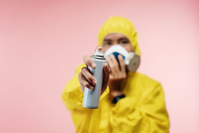 Homme en habit biohazard prêt à désinfecter une surface