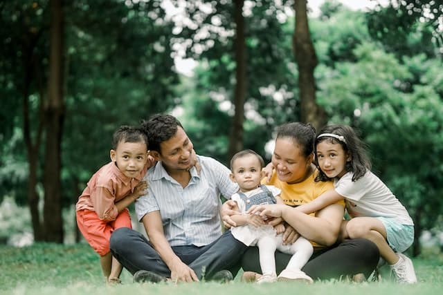 Famille heureuse assise sur le gazon