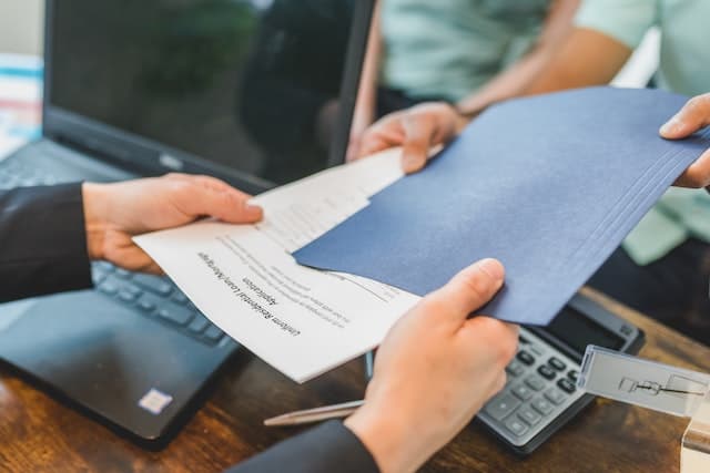 Client et courtier tenant un contrat d’hypothèque