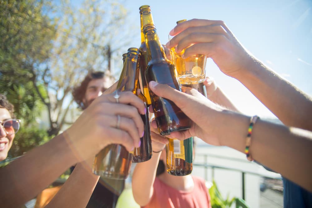 Amis trinquant à leur déménagement avec des bouteilles de bière