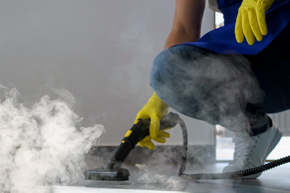 Nettoyeur professionnel lavant un tapis à la vapeur