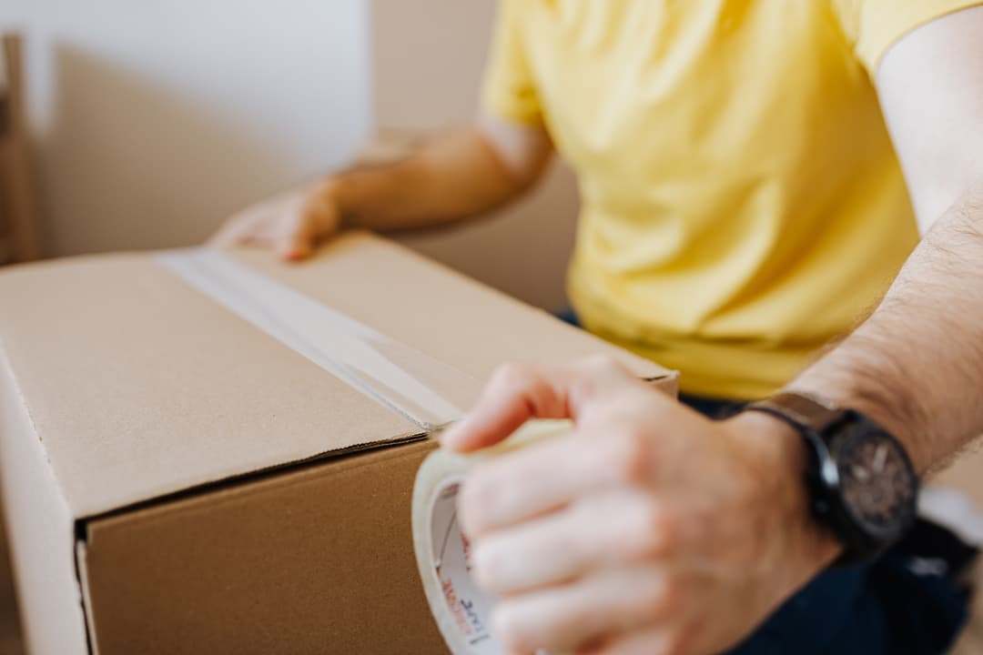 Homme fermant une boite de déménagement suite à un divorce