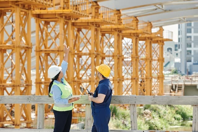 Deux travailleurs de la construction observant un bâtiment en construction