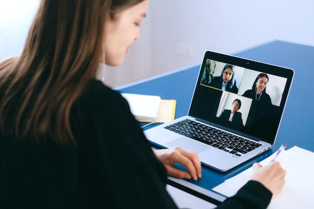 Femme d’affaires en conférence virtuelle avec d’autres experts