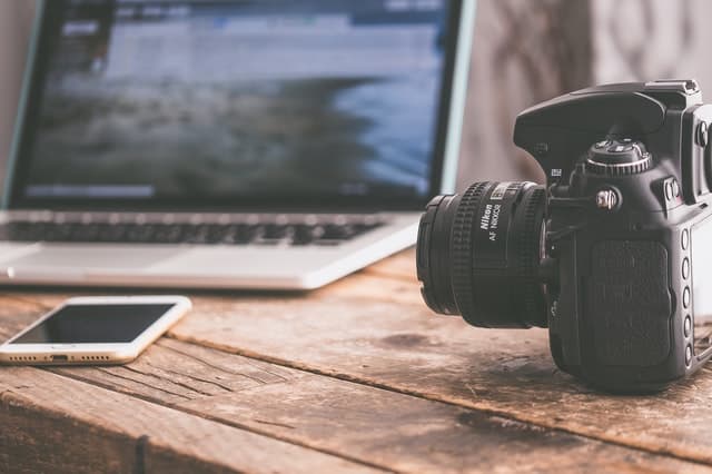 Appareil photo posé sur une table à côté d'un ordinateur