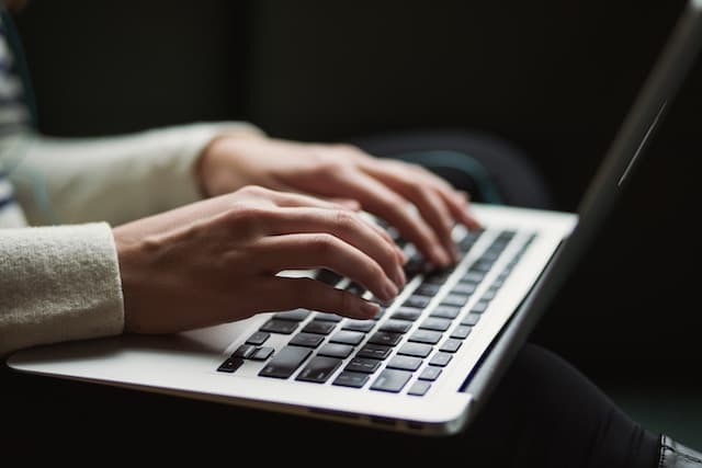 Personne écrivant son inventaire de biens sur un ordinateur portable