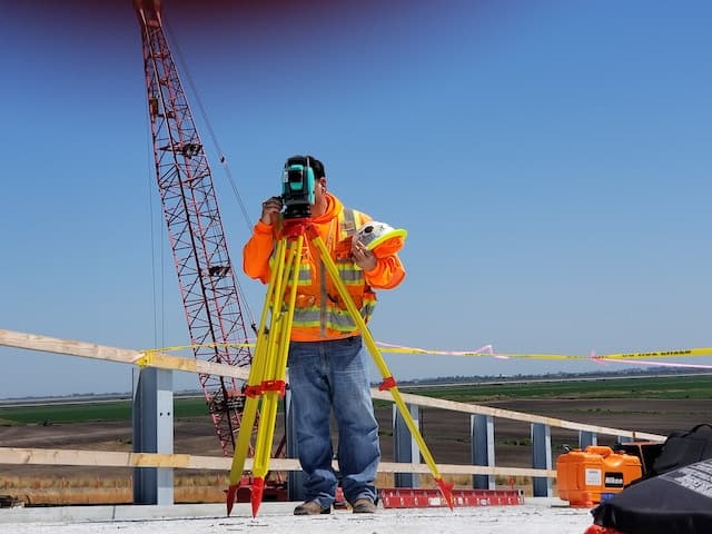 Arpenteur-géomètre utilisant un théodolite sur un chantier de construction