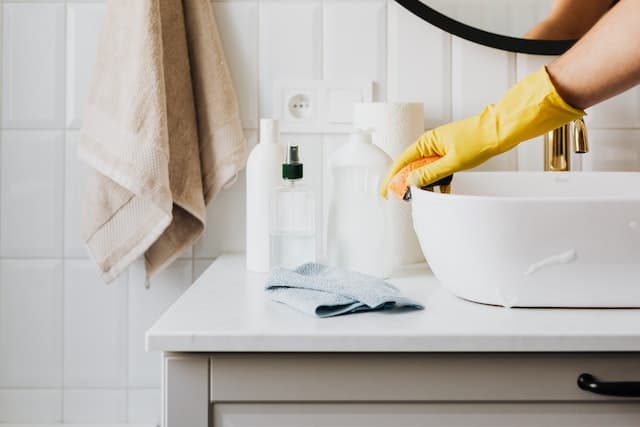 Personne nettoyant le lavabo de la salle de bain